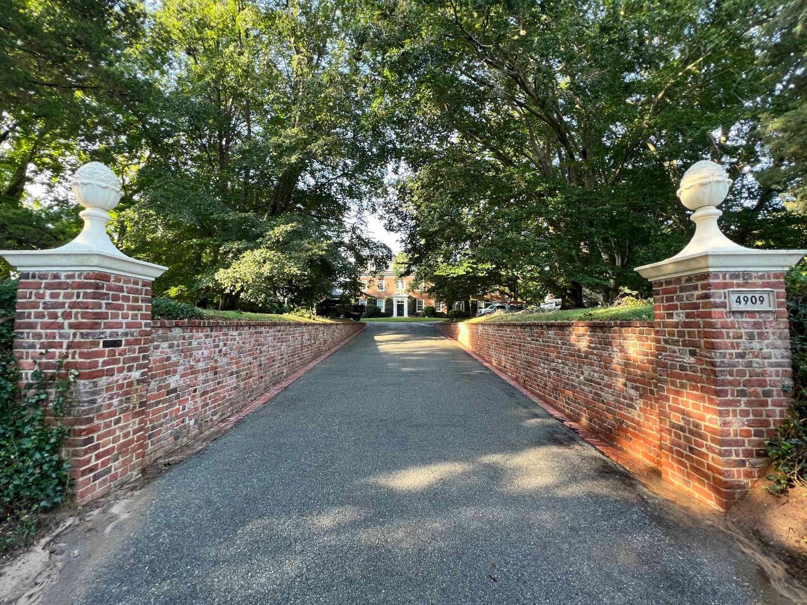 Residential brick driveway retaining wall covered in dirt and growth before professional soft washing and cleaning by alpha exterior solutions near mechanicsville