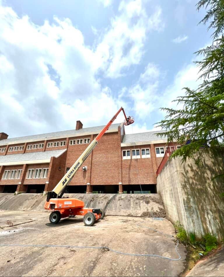 Alpha exterior solutions preforming commercial building washing and roof cleaning in cherry picker