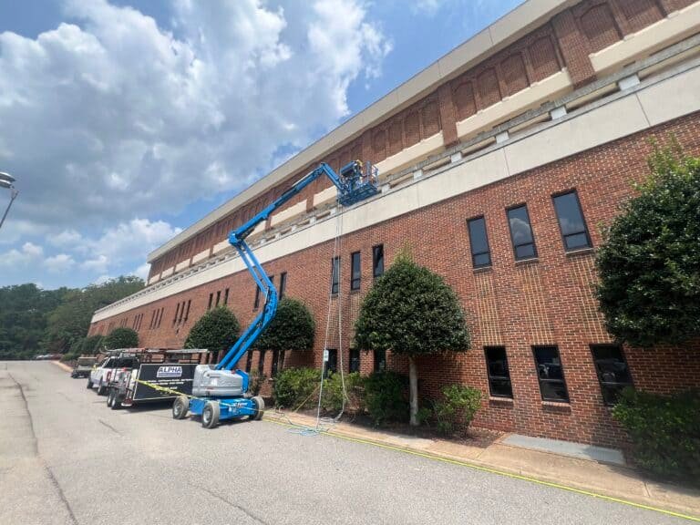 Alpha Exterior Solutions performing professional cleaning and commercial building washing in air lift