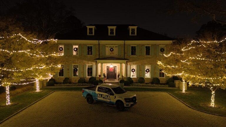 residential home decorated for christmas with christmas lights in trees and wreaths on windows in colonial heights va
