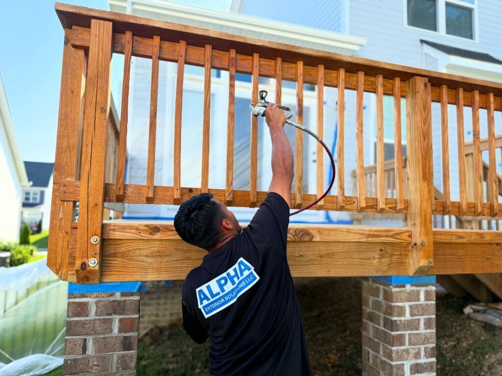 Alpha Exterior Solutions expertly staining a deck in Richmond, VA. We offer professional deck staining and fence staining services to protect and beautify your outdoor spaces.