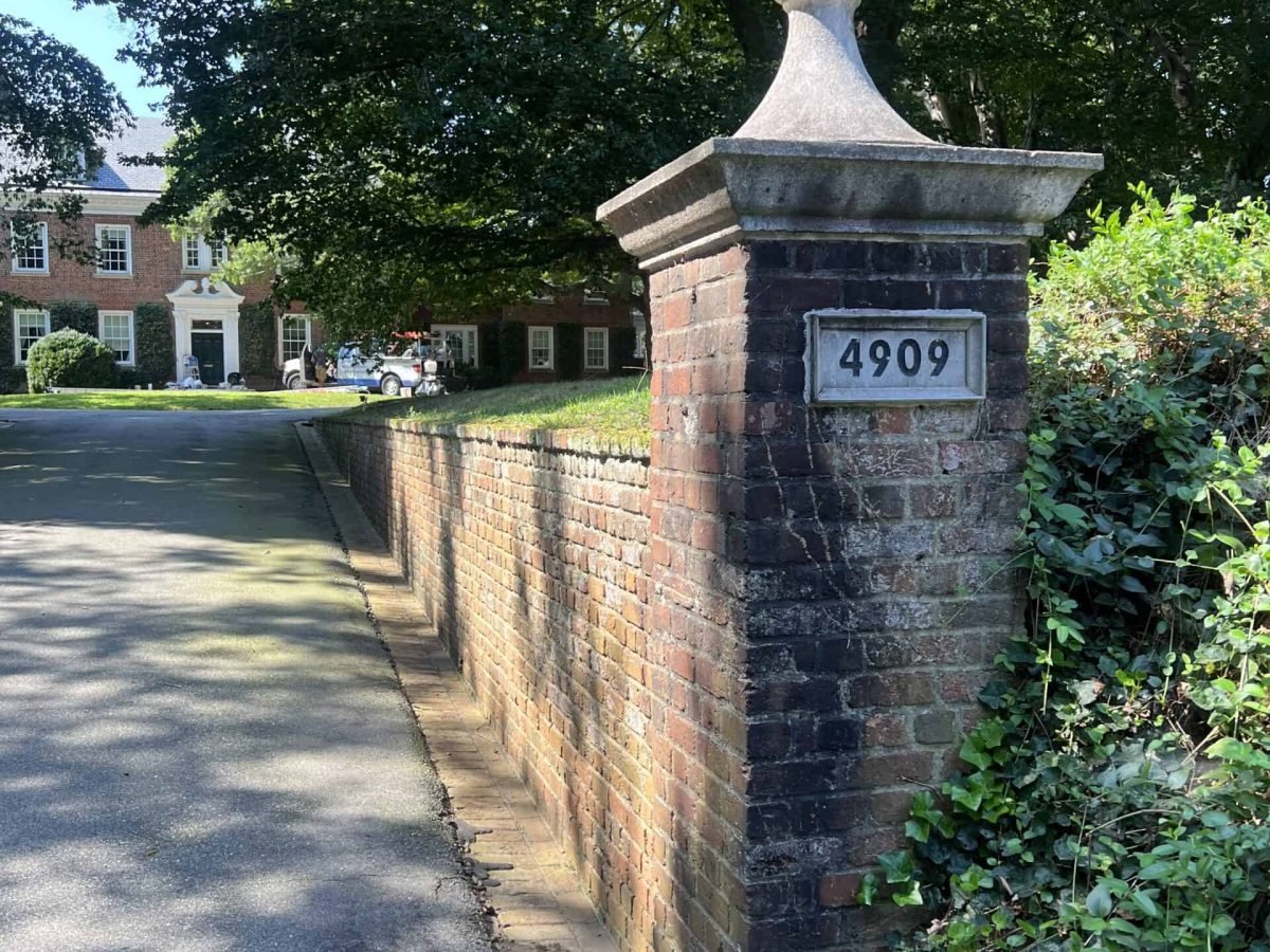 Residential brick driveway retaining wall covered in dirt and growth before professional soft washing and cleaning by alpha exterior solutions near mechanicsville
