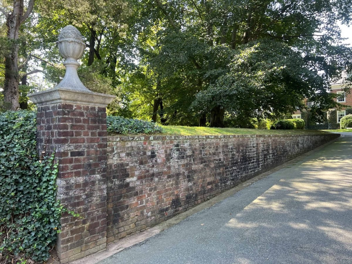 Residential brick driveway retaining wall covered in dirt and growth before professional soft washing and cleaning by alpha exterior solutions near mechanicsville