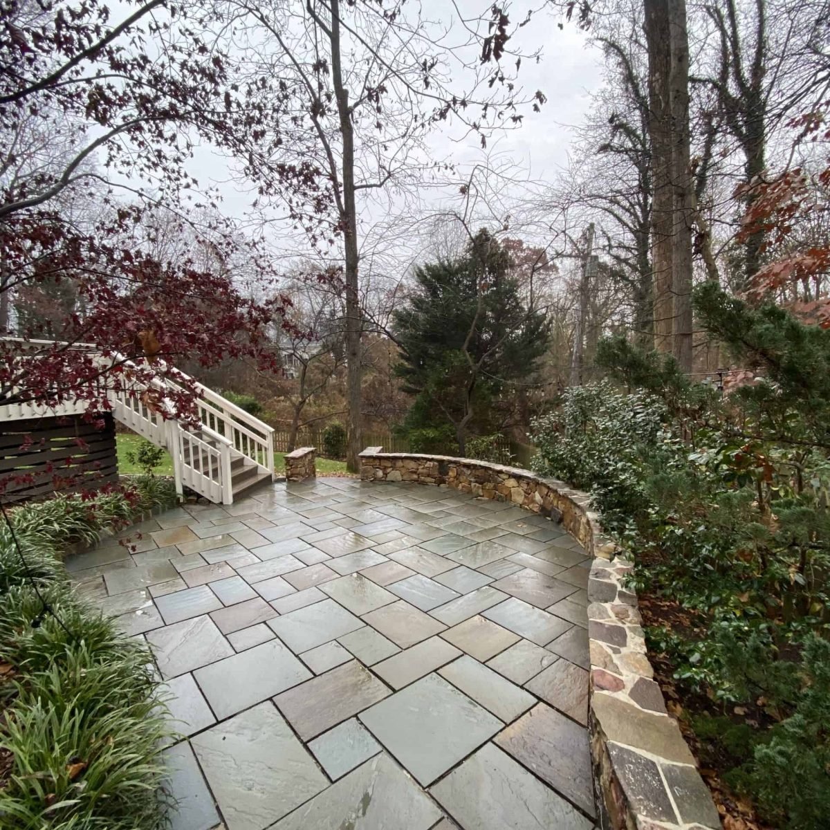 after photo of outdoor patio and rock retaining wall after power washing and paver sealing preformed by alpha exterior solutions